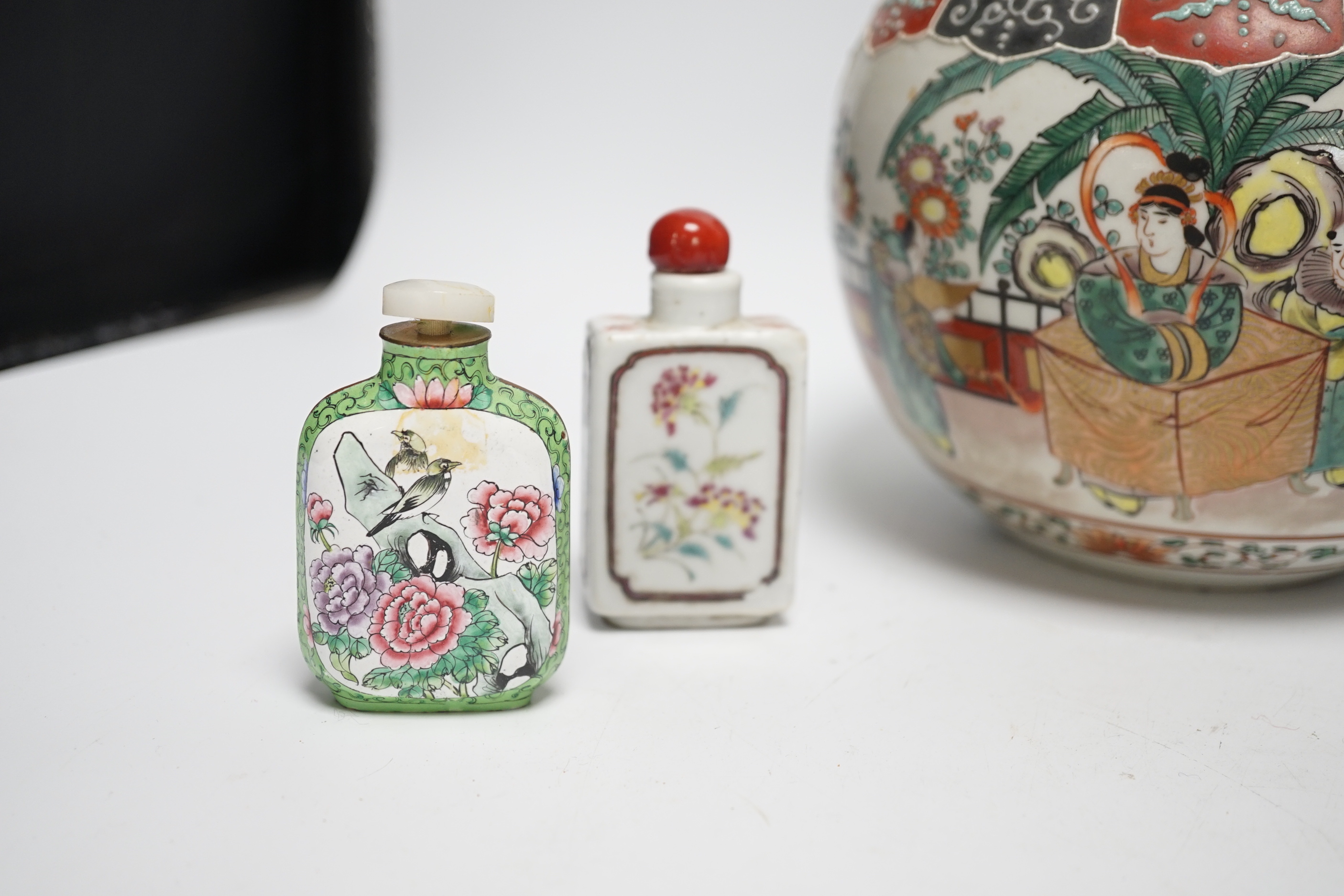 An early 20th century Japanese famille rose snuff bottle together with three others and a lidded jar